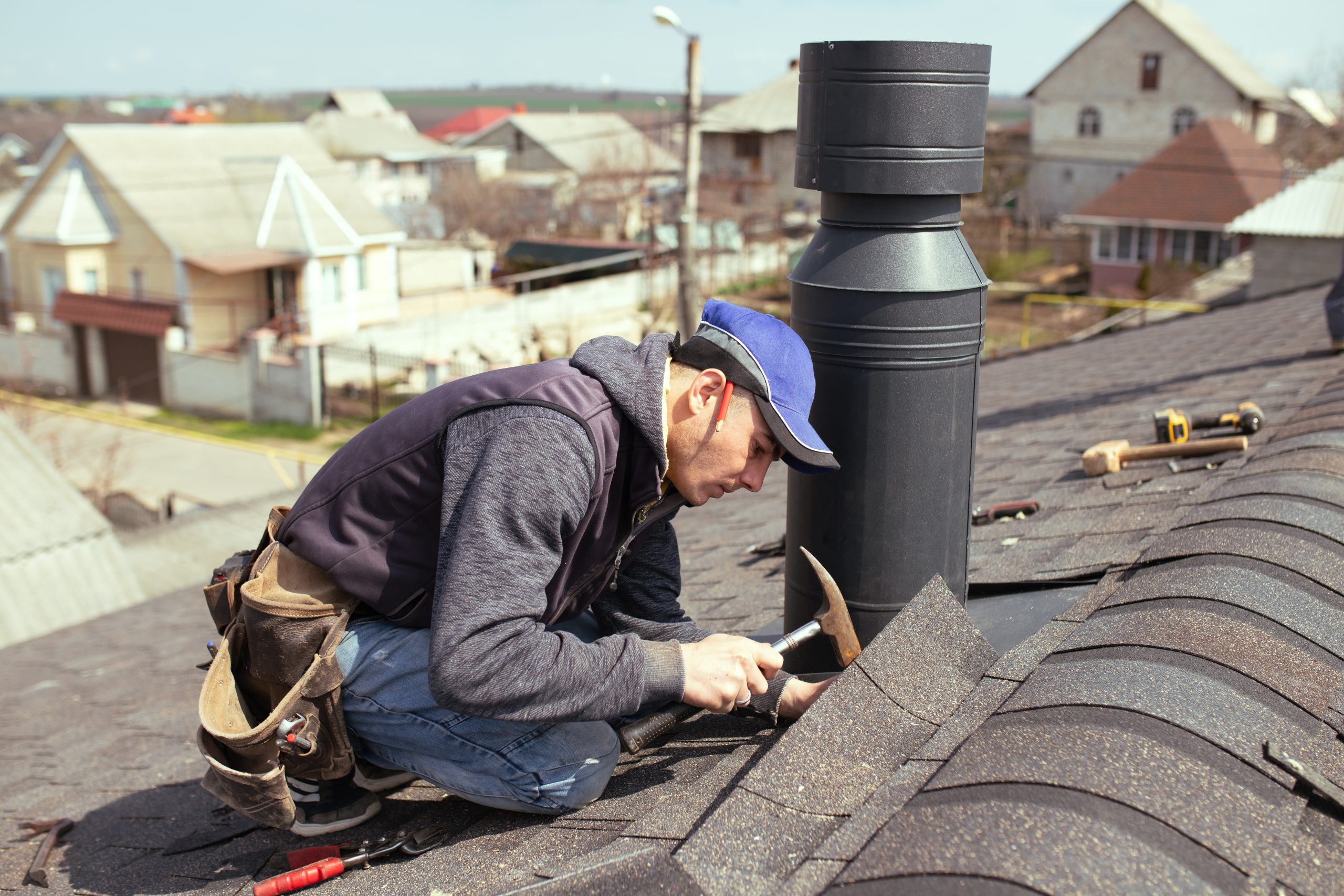 Roofer repairing cracked shingles